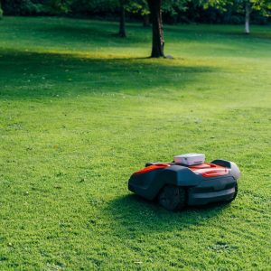 Robotic lawn mower cutting grass in a field.